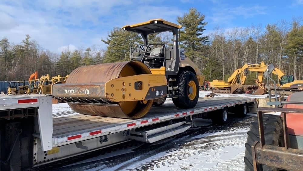 Road roller loaded on a flatbed trailer
